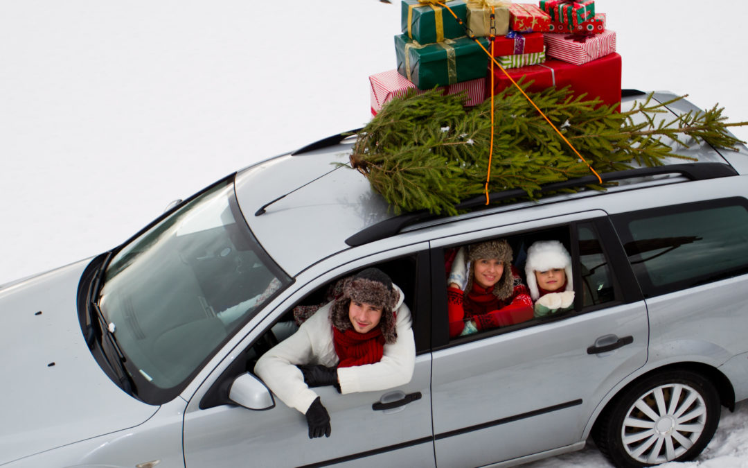 Family in a car surrounded by snow with Christmas presents and tree on the roof of the car - Lasky Justus Law - Your Savannah Law Firm for Car Wrecks and Truck Accidents