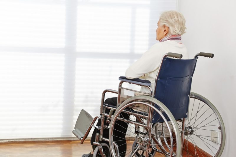 Elderly person in a wheelchair facing closed blinds - Lasky Justus Law - Your Savannah Law Firm for Nursing Home Abuse